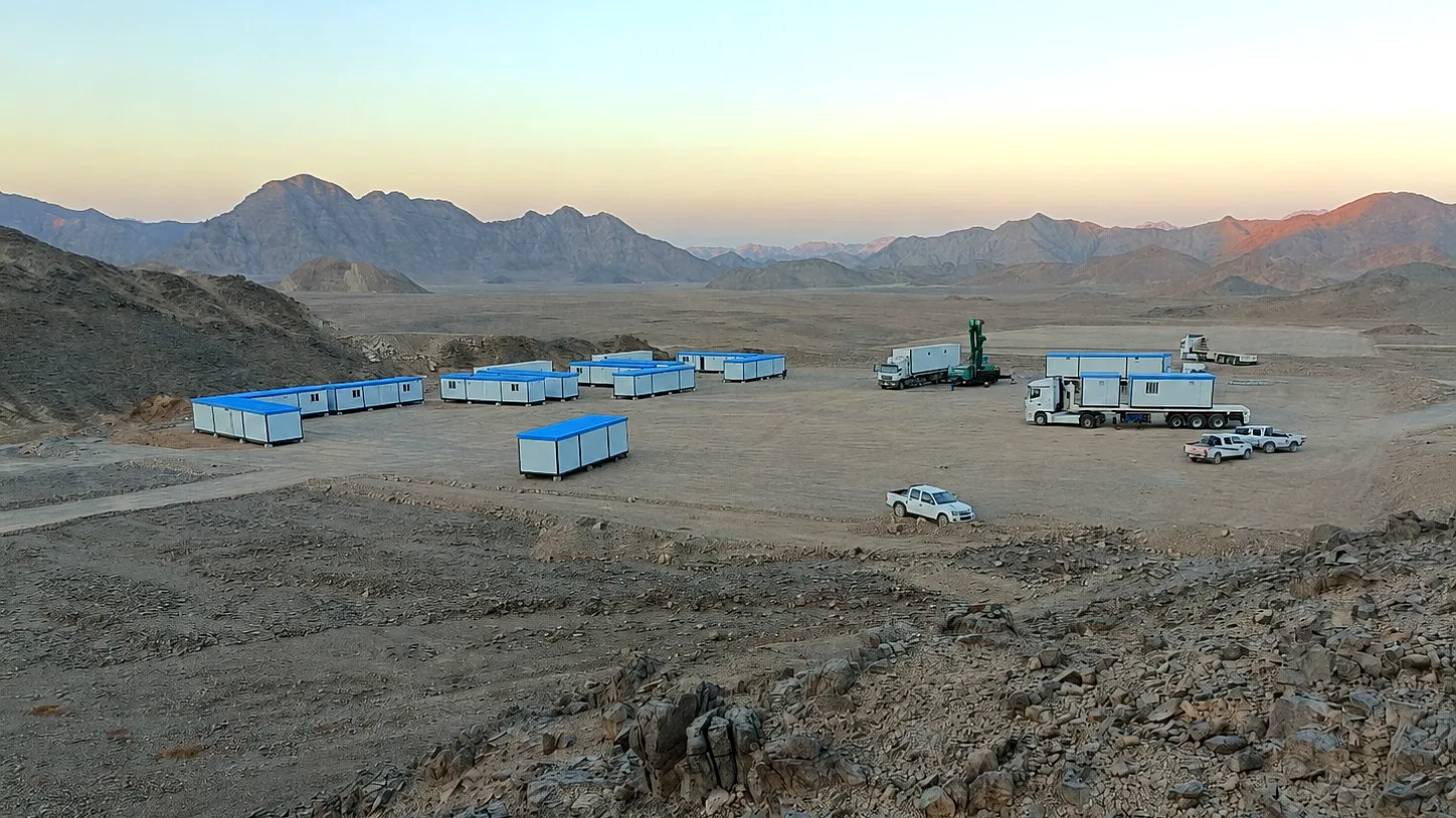 Remote mining camp with site buildings and logistics vehicles
